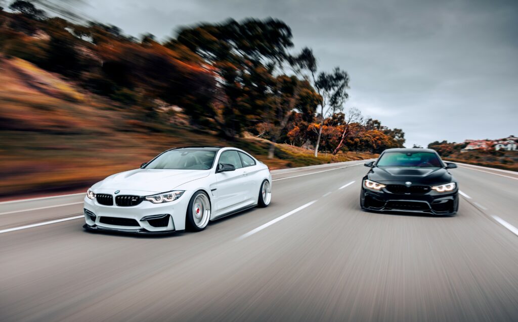 Two BMWs driving alongside one another